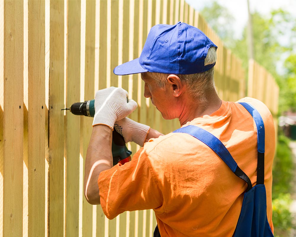 fence installer using drill on wooden fence baton rouge la
